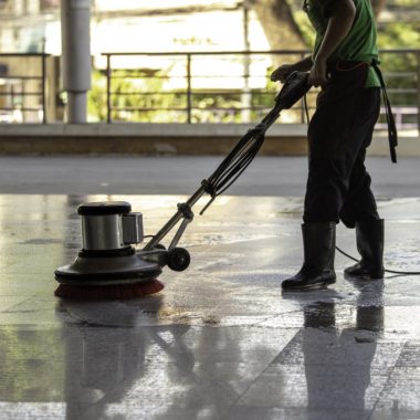 The worker cleaning floor exterior walkway using polishing machine and chemical or acid